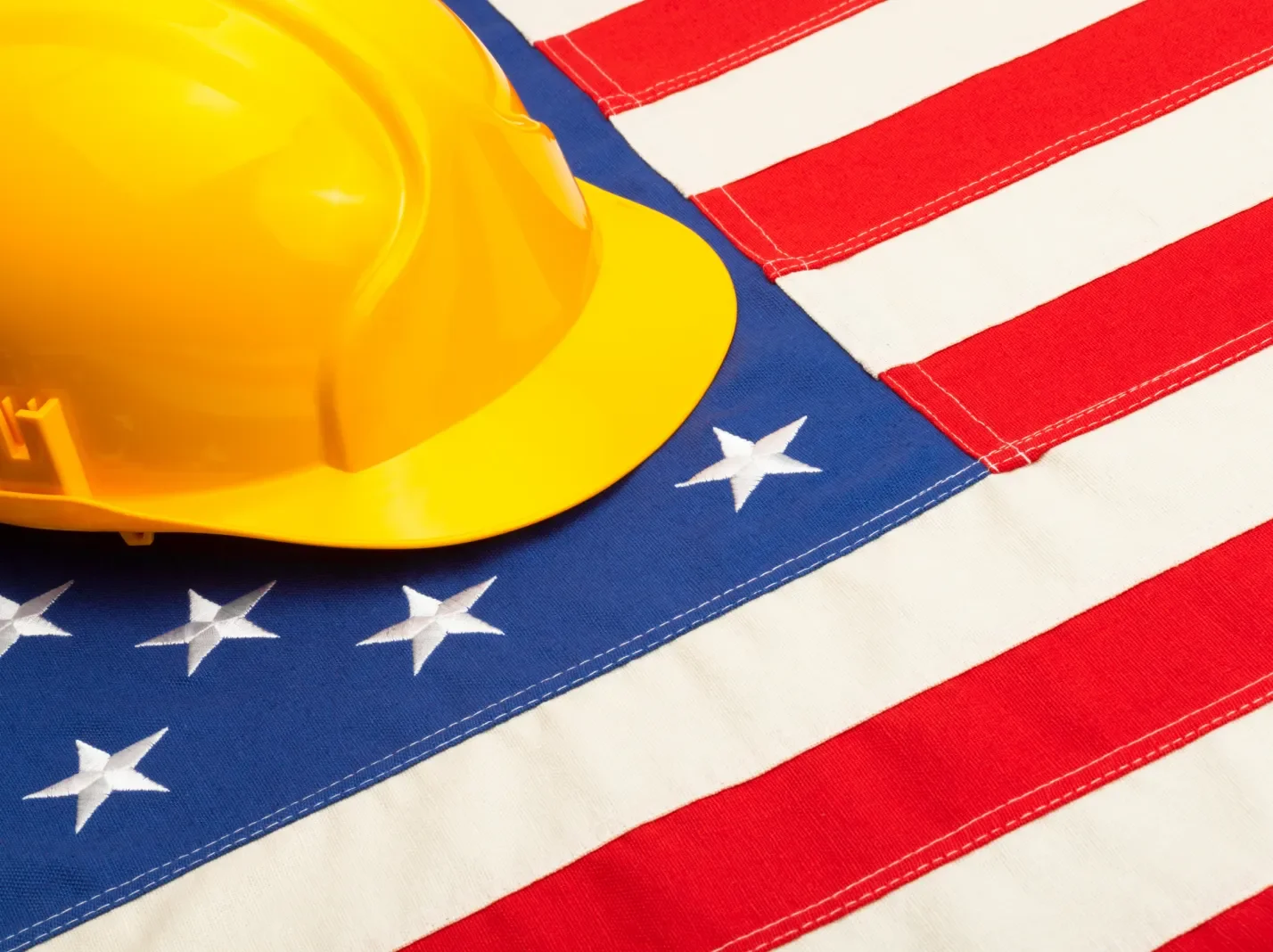 Yellow construction hard had sitting on a U.S. flag
